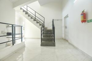 a staircase in a white room with a tile floor at FabExpress Joey's Place in Nerul