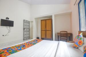 a bedroom with a bed and a tv on the wall at FabExpress Joey's Place in Nerul