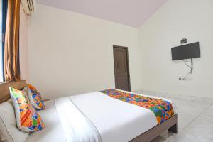 a bedroom with a bed and a tv on the wall at FabExpress Joey's Place in Nerul