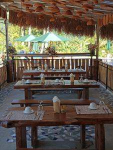 restauracja z drewnianymi stołami i parasolami w obiekcie Sekumpul Bali Hidden Space w mieście Singaraja