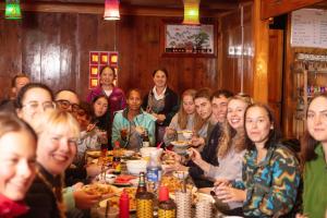 a group of people sitting at a table eating at Zili Homestay in Sa Pa