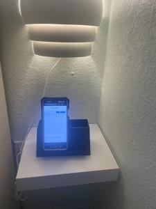 a cell phone sitting on a shelf under a light at The Tiny Cottage in the Springs/ Central FL in Orlando