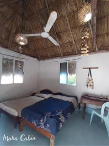 a bedroom with a bed and a ceiling fan at Maha cabin beach access in Mahahual