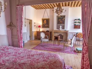 a bedroom with a bed and a table and chairs at La Chanoinesse in Salles-Arbuissonnas