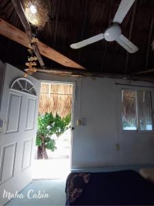 a room with a door and a ceiling fan at Maha cabin beach access in Mahahual