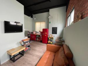 a living room with a couch and a flat screen tv at HeMei Homestay in Ho-mei