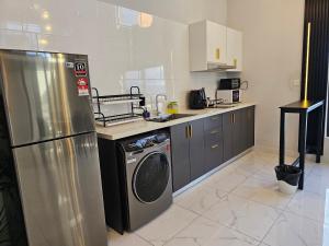 een keuken met een koelkast en een wasmachine bij Arte Cheras The Premium Suites by iLuxHome in Kuala Lumpur