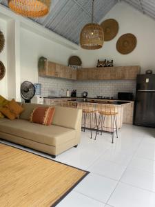 a living room with a couch and a kitchen at Pennylane Villa in Seminyak