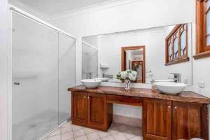 een badkamer met 2 wastafels en een douche bij Rosebay water front 4 bd home in Brisbane