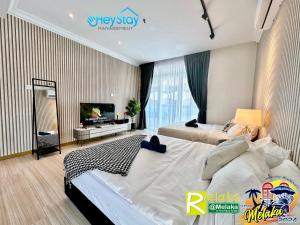マラッカにあるTheWave Residence By Heystay Managementのベッドルーム1室(ベッド2台、薄型テレビ付)