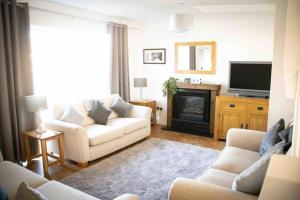 sala de estar con sofá blanco y TV en Botany Bay House with Hot Tub, close to Beach, en Kent