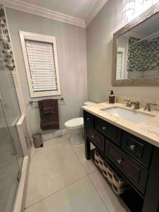La salle de bains est pourvue d'un lavabo, de toilettes et d'un miroir. dans l'établissement New Beach Cabana with Mini Golf, à Venice