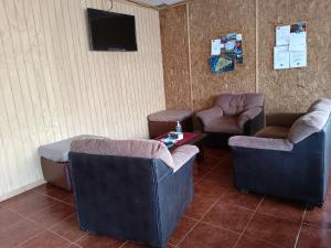 a waiting room with couches and chairs and a tv at Hostal Kaiheke in Hanga Roa
