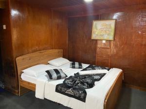 a bedroom with two beds in a wooden wall at happy trust happy inn in Nuwara Eliya