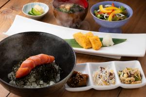 uma mesa com um wok e um prato de comida em HOTEL MYSTAYS Fukuoka Tenjin em Fukuoka