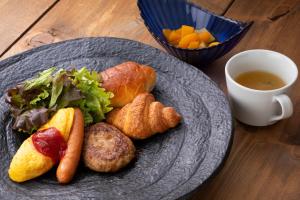 een bord eten op een tafel met een kopje koffie bij HOTEL MYSTAYS Fukuoka Tenjin in Fukuoka