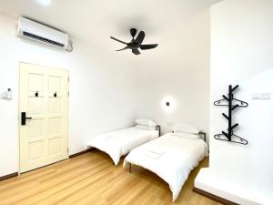 2 camas en una habitación con ventilador de techo en Grace Homestay Tawau, en Tawau