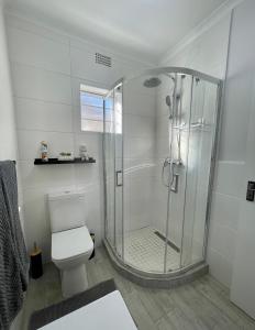 a bathroom with a shower and a toilet at Claptons Cottage 12 in Jeffreys Bay