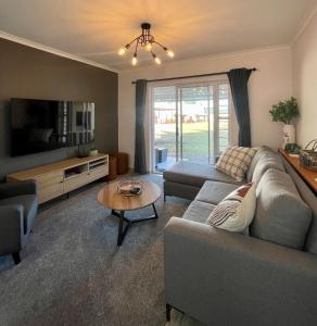 ein Wohnzimmer mit einem Sofa und einem Tisch in der Unterkunft Claptons Cottage 12 in Jeffreys Bay