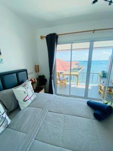 1 dormitorio con 1 cama grande y vistas al océano en บ้านพักการ์ฟิลด์ ซีวิว เกาะล้าน en Ko Larn