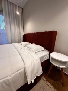 a small bedroom with a bed and a table at Duplex avec Rooftop a la Marsa in La Marsa