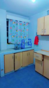 a blue kitchen with a sink and a window at Nabbynates bnbs in Eldoret