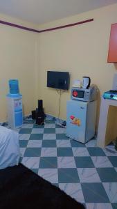 a room with a tiled floor with a computer and a tv at Nabbynates bnbs in Eldoret