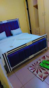 a bedroom with a large bed with a blue frame at Nabbynates bnbs in Eldoret