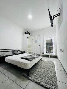 a white bedroom with a bed and a rug at CASA AMBAR in Tijuana