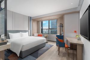 Cette chambre comprend un lit et un bureau. dans l'établissement Holiday Inn Express Changsha Development Zone, an IHG Hotel, à Xingsha