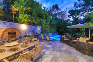 un patio con tavolo, sedie e piscina di Villa with jungle view & pool near Manuel Antonio a Quepos