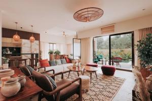uma sala de estar com um sofá e uma mesa em Eclectic Luxury 3bhk Villa with Private Pool em Mapuçá