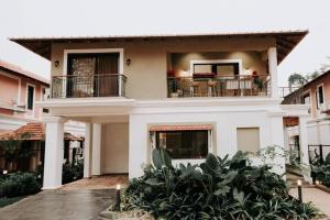 uma grande casa branca com uma varanda em Eclectic Luxury 3bhk Villa with Private Pool em Mapuçá