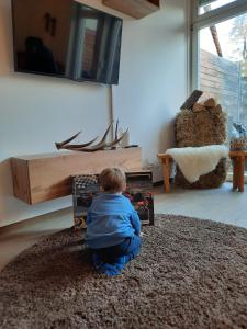 un bambino seduto per terra in un soggiorno di Schlossblick Heroldsberg a Heroldsberg