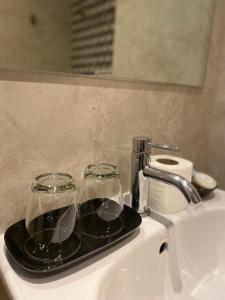 a tray with two glasses sitting on top of a sink at Infinite Hotel-Ratchada in Bangkok