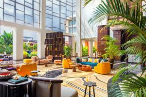 a lobby with yellow and blue furniture and plants at The Westin Goa, Anjuna in Anjuna
