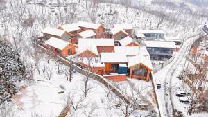 an aerial view of a house covered in snow at Sansa Village Boutique Hotel at Mutianyu Great Wall in Huairou