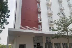 a tall white building with a red at Barata Home Aeropolis in Tangerang
