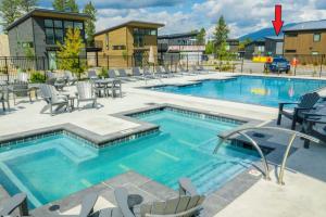 a swimming pool with chairs and tables and a building at Mountain View Chalet at The Quarry - Sleeps 6! in Whitefish