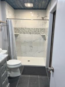 La salle de bains blanche est pourvue d'une douche et de toilettes. dans l'établissement Harbor Island D112, à Oceanmarsh Subdivision