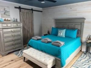 a bedroom with a blue bed and a dresser at Harbor Island D112 in Oceanmarsh Subdivision