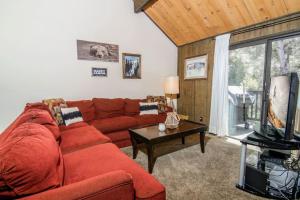 a living room with a red couch and a television at Broomall at Snow Summit Ski Resort in Big Bear Lake