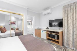 a hotel room with a bed and a tv at Club Wyndham Pokolbin Hill in Pokolbin
