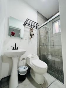a bathroom with a toilet and a sink and a shower at CASA AMBAR in Tijuana