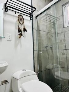 a bathroom with a toilet and a glass shower at CASA AMBAR in Tijuana