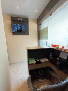 an office with a desk and a tv on the wall at Hotel Powai Residency in Mumbai