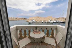 a balcony with a table and chairs and a view of a harbor at Harbour view in Senglea