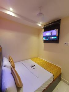 a bedroom with a bed and a tv on the wall at Hotel Powai Residency in Mumbai