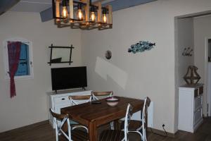 une salle à manger avec une table et une télévision dans l'établissement Maison bord de mer, à Saint Cyprien Plage