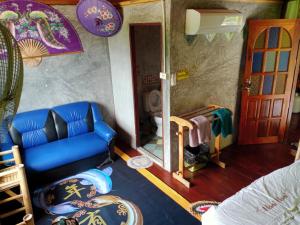 a living room with a blue couch and a mirror at Comon Bungalow HaadChaoPhao in Haad Chao Phao